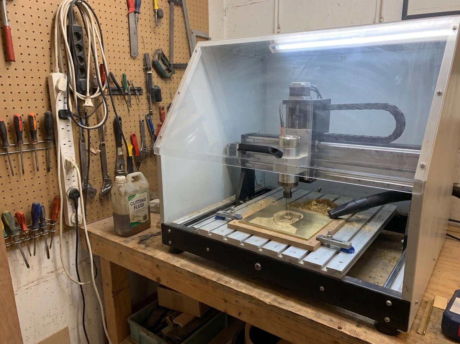 A portrait engraved in a brass plate on the engraving machine, chips still on the bed
