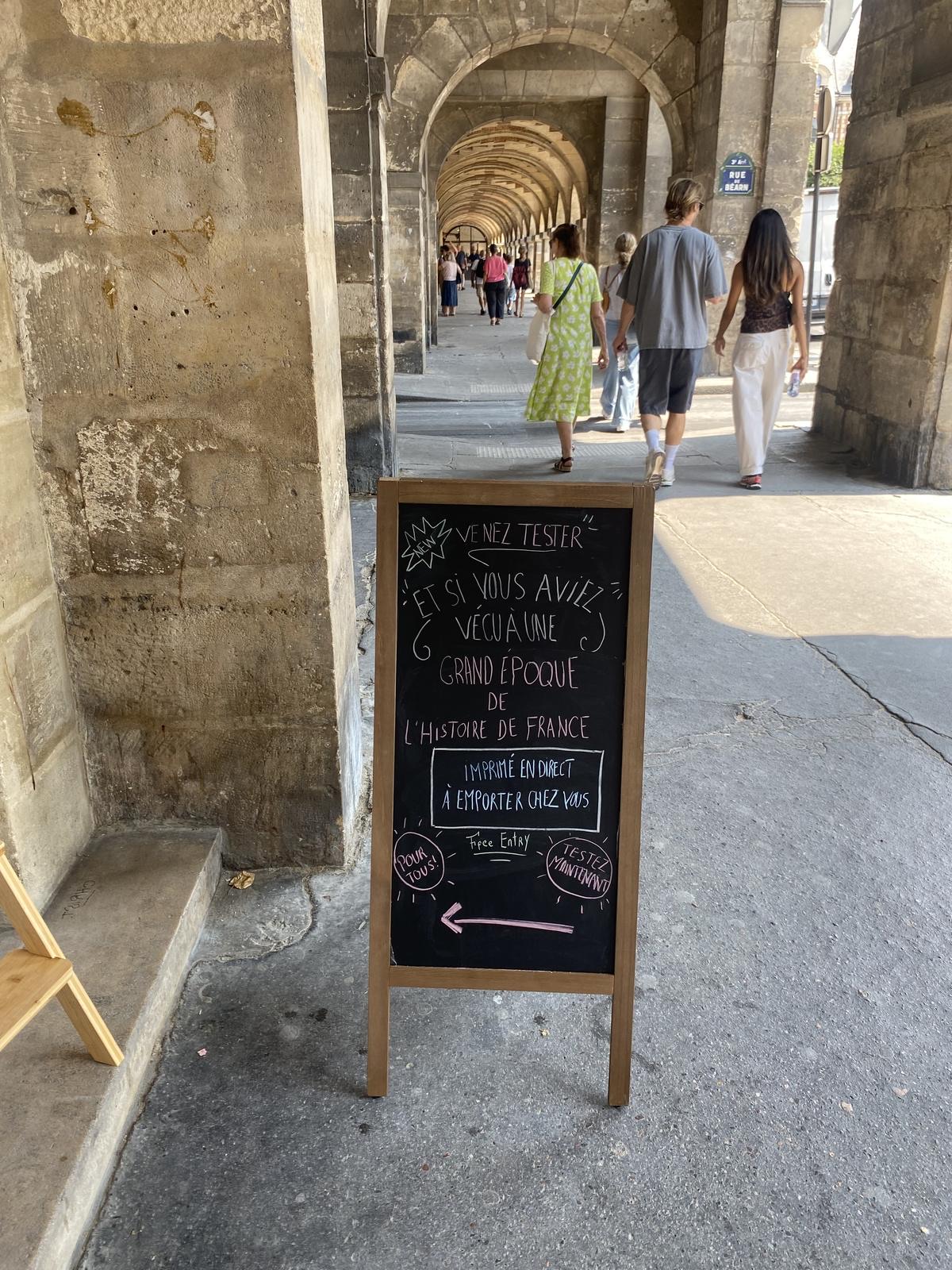The chalkboard sign under the arcades of Place des Vosges